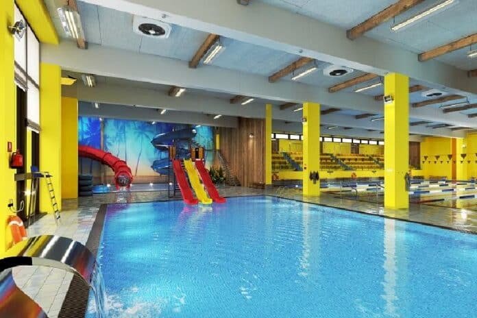 Indoor swimming pool complex with colorful water slides and lanes